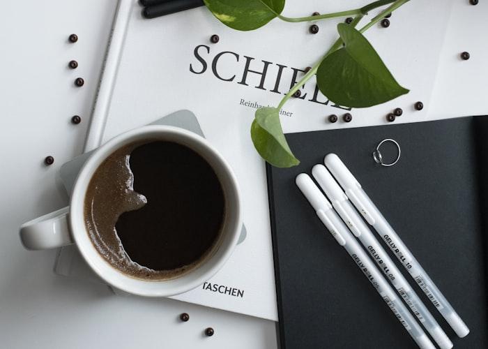 Cuaderno de notas y café, representando la investigación de nuevos tratamientos